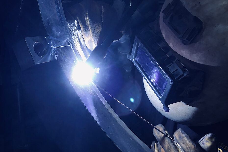 A zoomed photo of a welder wearing protective mask.