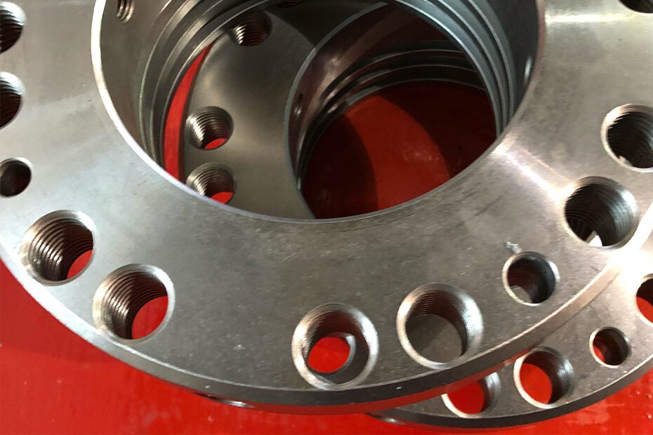 A stacked of steel flange on a red surface