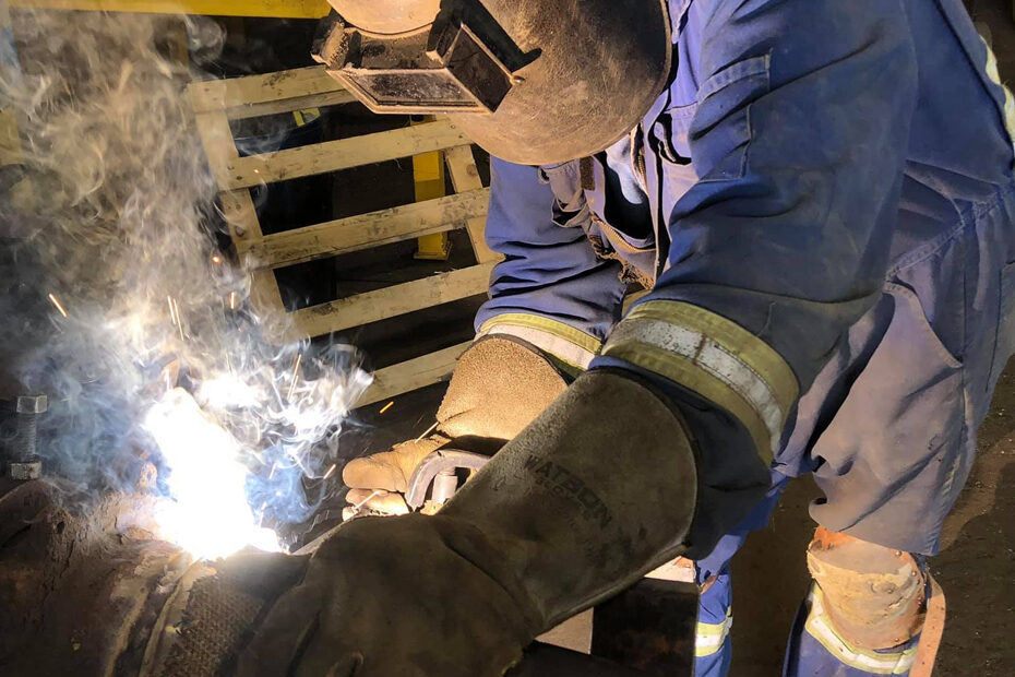 A welder hard at work wearing protective gear